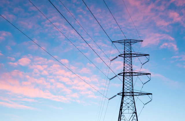 Electricity transmission tower against an orange sky